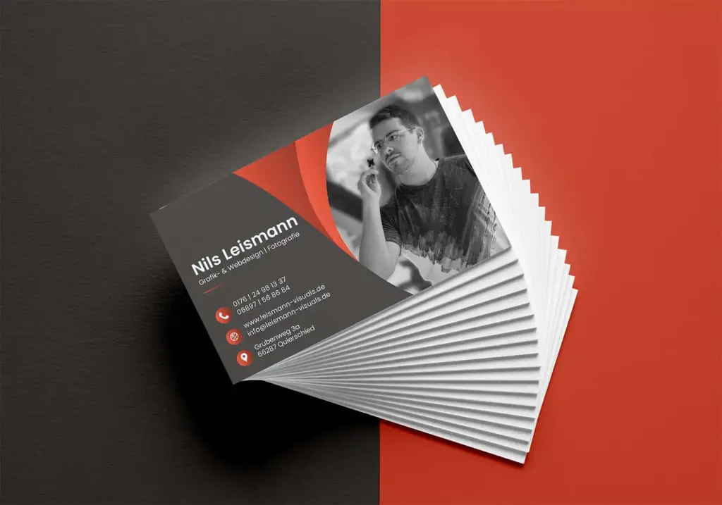 Gestapelte Visitenkarten für Leismann Visuals mit modernem Schwarz-Rot-Design, Foto von Nils Leismann und Kontaktdaten aus Quierschied, Saarland.